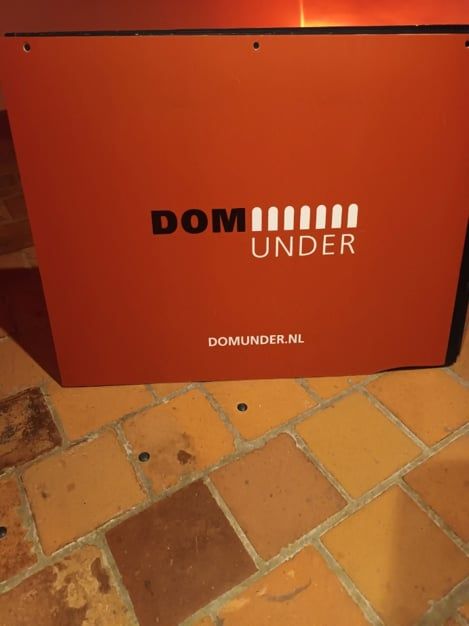 Een oranje bord met de naam DOMunder.